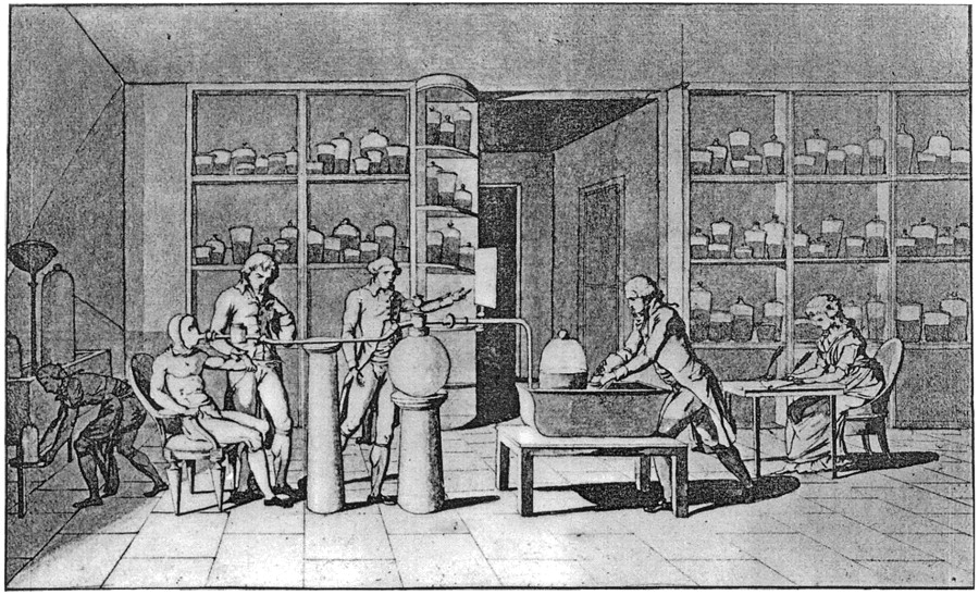 Lavoisier (standing at table) conducting an experiment on respiration with his wife taking notes