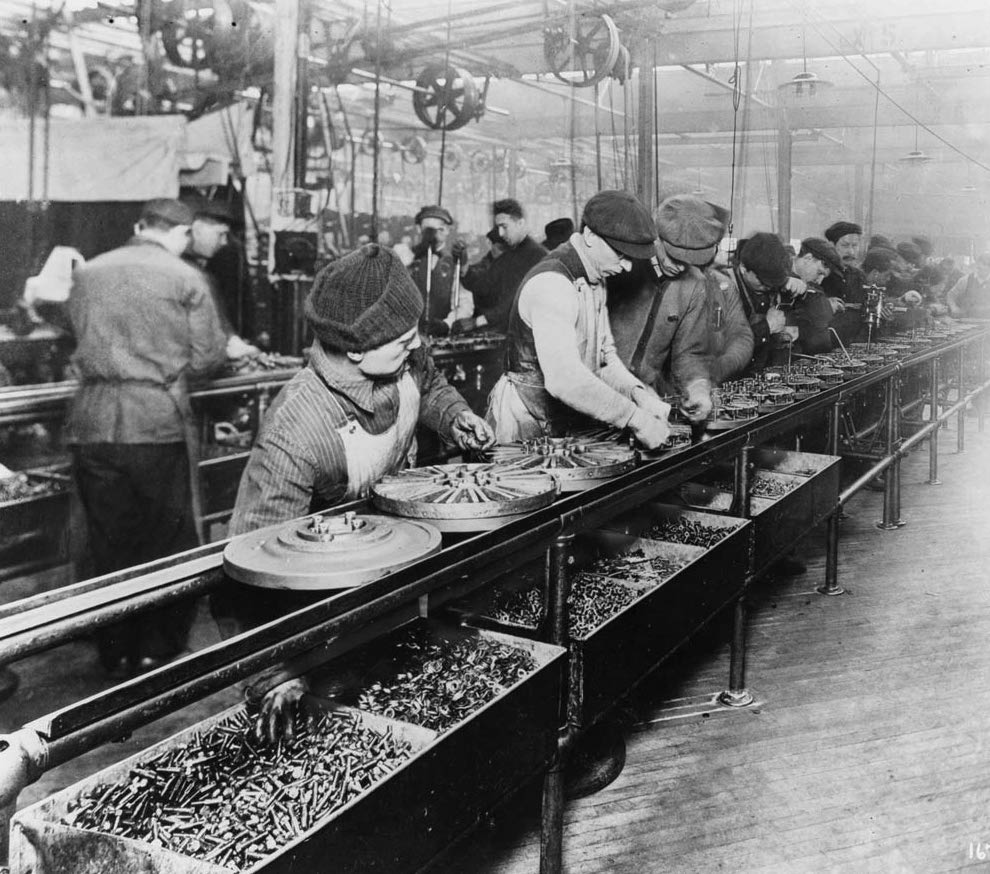 Workers on Ford's first moving assembly line, assembling magnetos