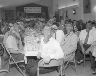 Highland Park Optimist Club wearing smog-gas masks at banquet, Los Angeles, c1954
